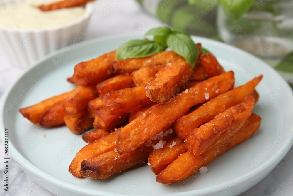 Sweet potato fries and basil on table, closeup Sweet potato fries and basil on table, closeup
