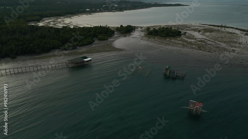 Aerial orbit above stilted homes of Taloot Argao Port's pier and surrounding waters at sunrise in Cebu, Philippines photo