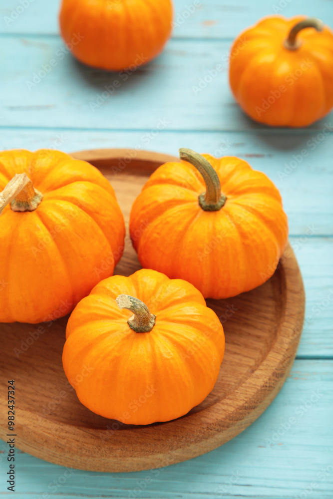 Autumn composition. Fresh orange and white pumpkin on wooden plate on blue wooden background. Top view Autumn composition. Fresh orange and white pumpkin on wooden plate on blue wooden background. Top view
