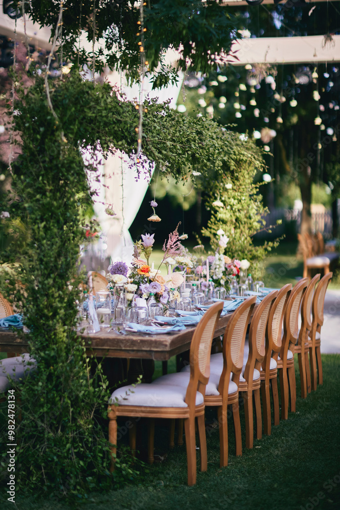 Outdoor Wedding Reception with Brown Chairs and Decorated Tables on a Green Lawn in a Scenic Nature Setting