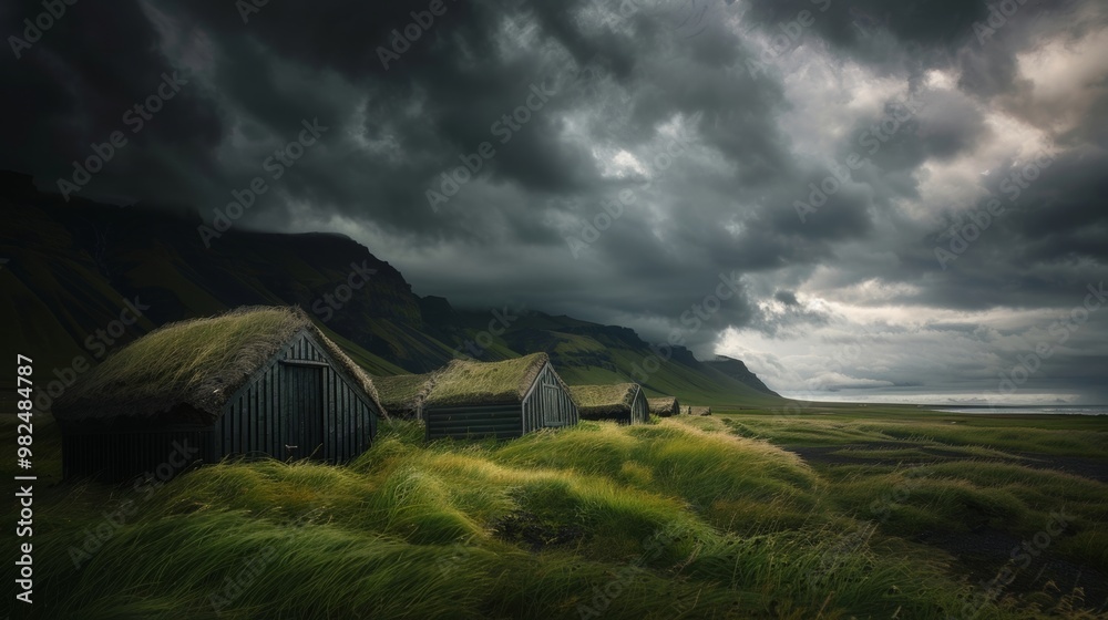 Mysterious Landscape with Old Houses Amidst Dark Clouds and Lush Green Fields