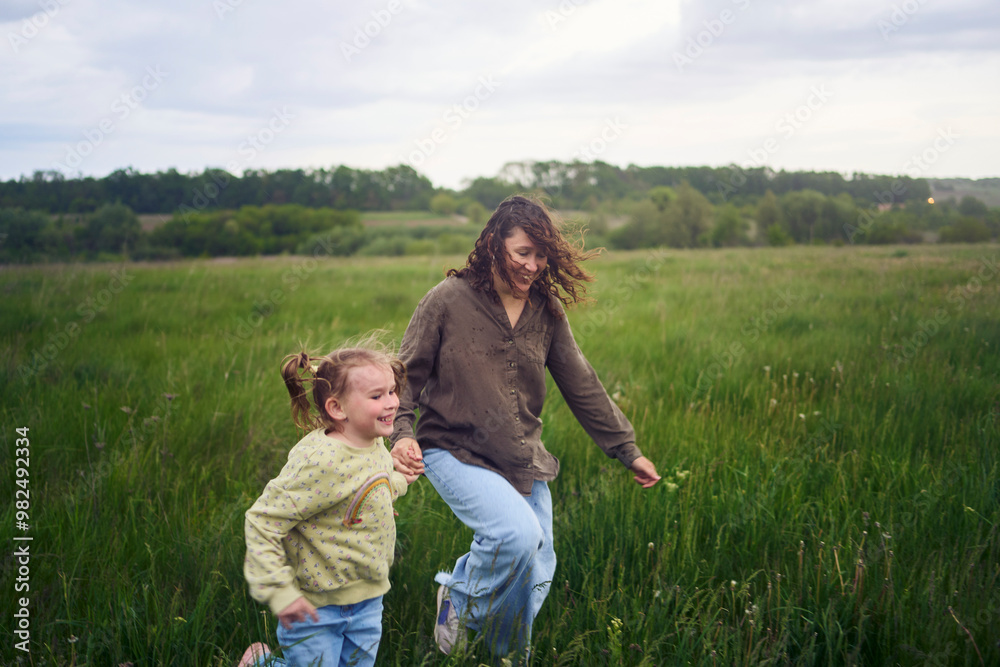 two little sisters and mother run and launch a kite in a field two little sisters and mother run and launch a kite in a field