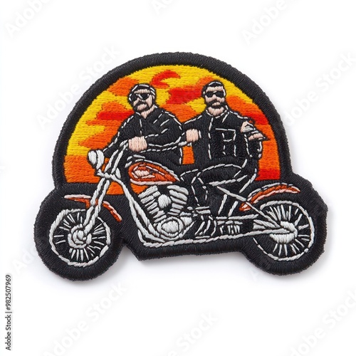 Two men on a motorcycle with a sunset in the background. The patch is black and embroidered with white, orange and yellow thread.
