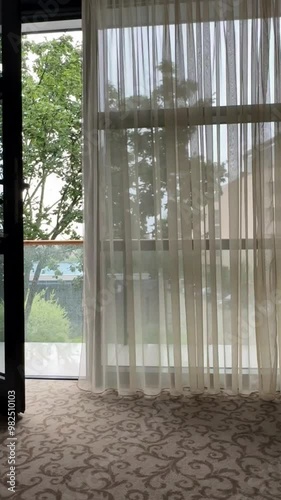 Window with curtain blowing in the wind