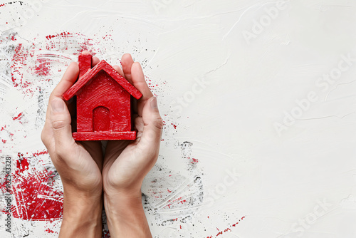 Overhead view on person hands holding red house model on white background. Home for sale, for rent, mortgage concept. Saving money. Copy space photo