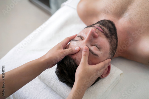 Relaxing Spa Experience with Gentle Facial Massage for Stress Relief and Rejuvenation in a Calming Wellness Environment, Featuring Skilled Hands Offering Soothing Face Therapy for Men