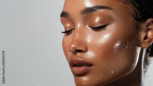 A woman with a dewy, glass skin finish, capturing the trend of glowing, healthy-looking skin in makeup.