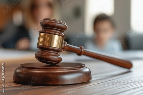 Focused gavel on a table with blurred family members in the background of a custody dispute