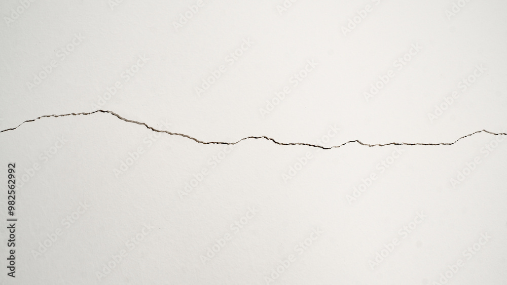 Deep crack on the white wall, which symbolizes the passage of time, wear and tear, aging Deep crack on the white wall, which symbolizes the passage of time, wear and tear, aging