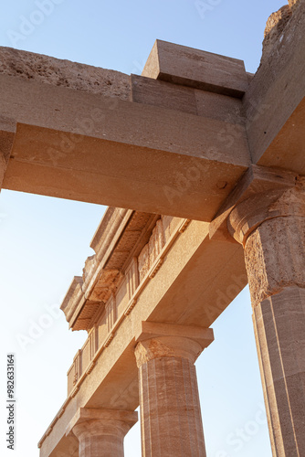 A detailde view of the remains of an ancient Greek temple. Low angle with clear sky as background. photo