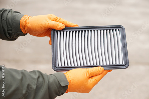 Closeup mechanic's hands hold air filter pad of car engine to check. Concept, car broken,repair and maintenace service. Dirty air fillter need to change for hygienic.     photo