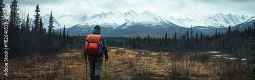 Rugged Adventurer Hiking in Snow-Capped Mountains with Backpack and Poles