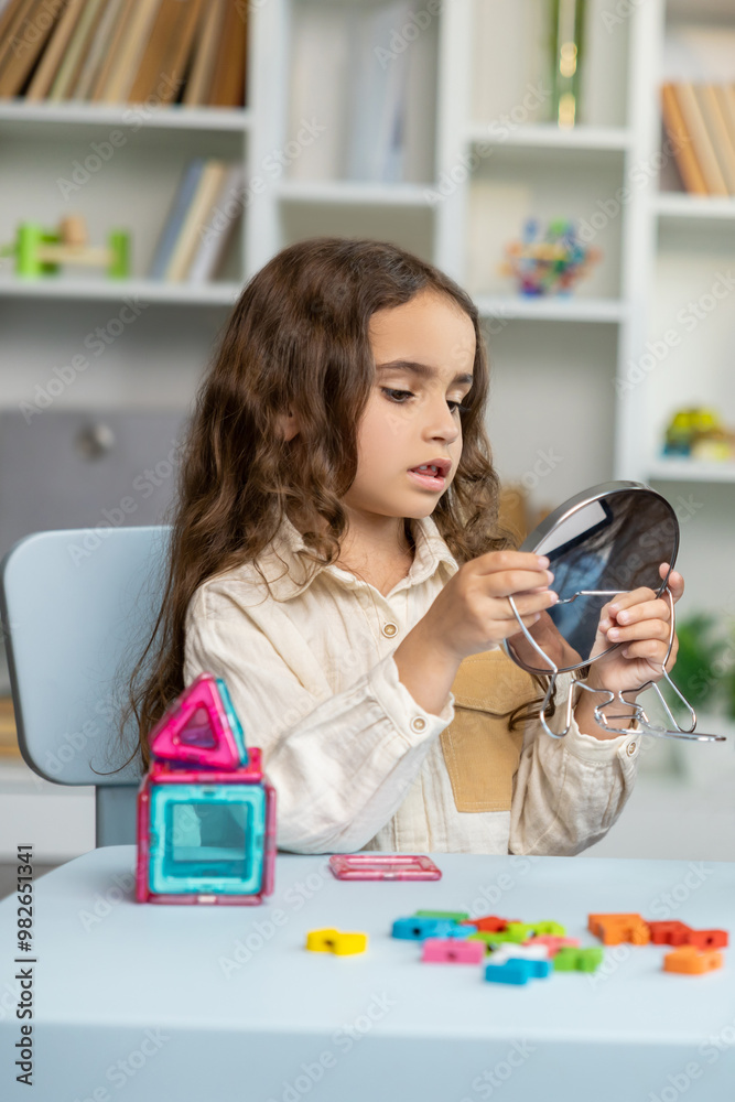 Cute long-haired girl working on her speech and looking involved and focused