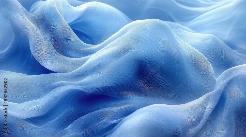 Fototapeta premium The soft, translucent blue fabric flows gracefully, creating an ethereal pattern that captures light and highlights its delicate texture