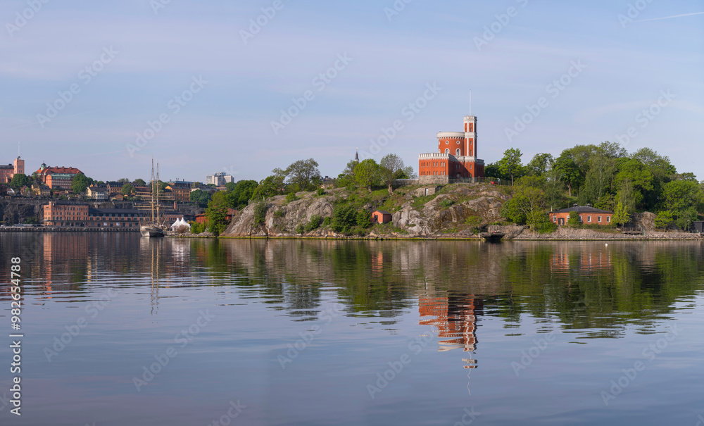 Fototapeta premium Panorama, old castle in the island Kastellholmen, sailing and commuter boats, the old town, a calm sunny summer morning in Stockholm