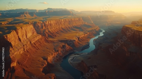 Aerial view of the Grand Canyon, showcasing deep orange and red cliffs, with the Colorado River winding below, illuminated by soft sunrise light, Realistic, Landscape, Warm tones