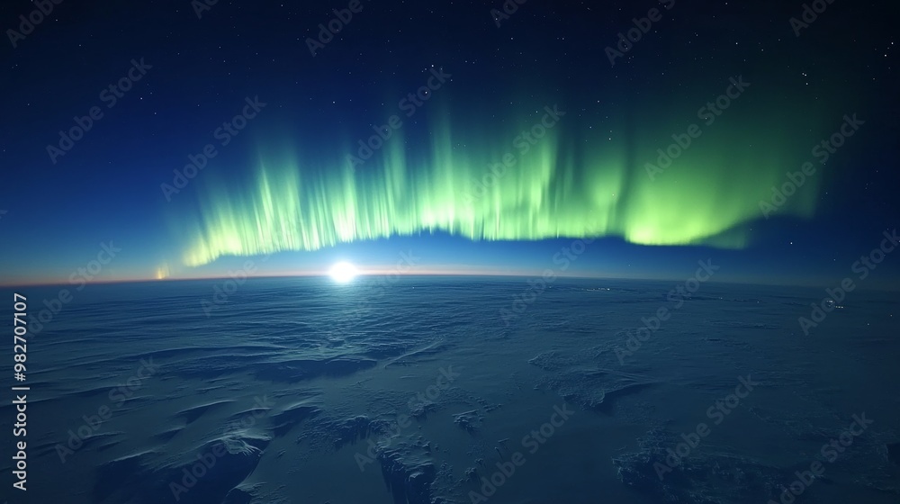 Naklejka premium Northern Lights from above, casting vibrant ribbons of light across a snow-covered Arctic expanse, capturing the beauty of untouched wilderness