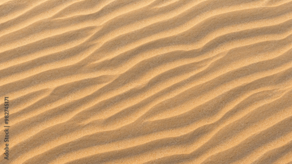 Sunlit Sand Texture with Soft Waves on Sandy Beach - Top View Sunlit Sand Texture with Soft Waves on Sandy Beach - Top View