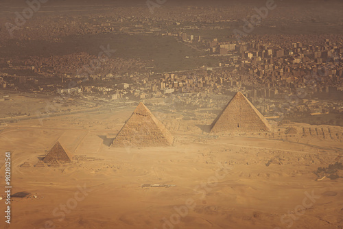 Fotografie The aerial panorama view of Egyptian pyramids of Giza, with Giza town and Cairo city districts is seen in the background