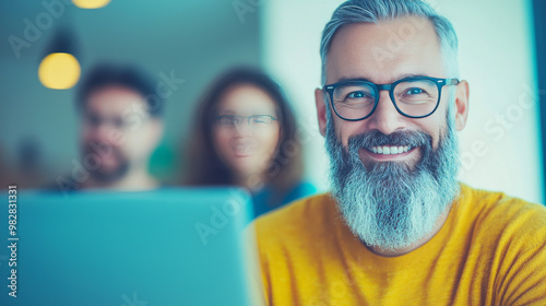 Smiling man with a beard working on a computer.