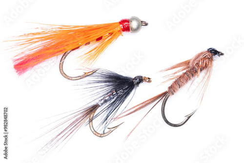 Slika na platnu Group of three fishing flies in orange, black and tan brown isolated on white background