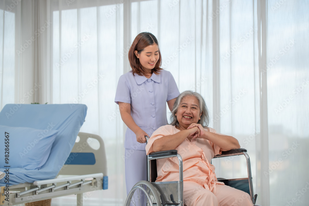 Asian nurse pushing senior female patient in a wheelchair at the hospital ward Asian nurse pushing senior female patient in a wheelchair at the hospital ward