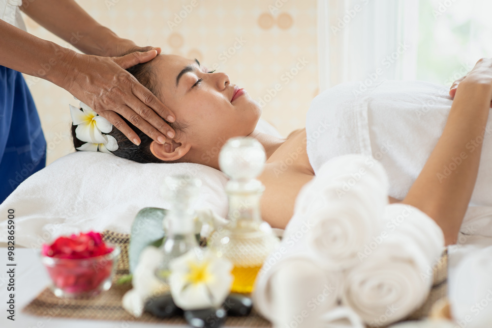 Young Asian woman getting massage in the spa salon, enjoying and relaxing