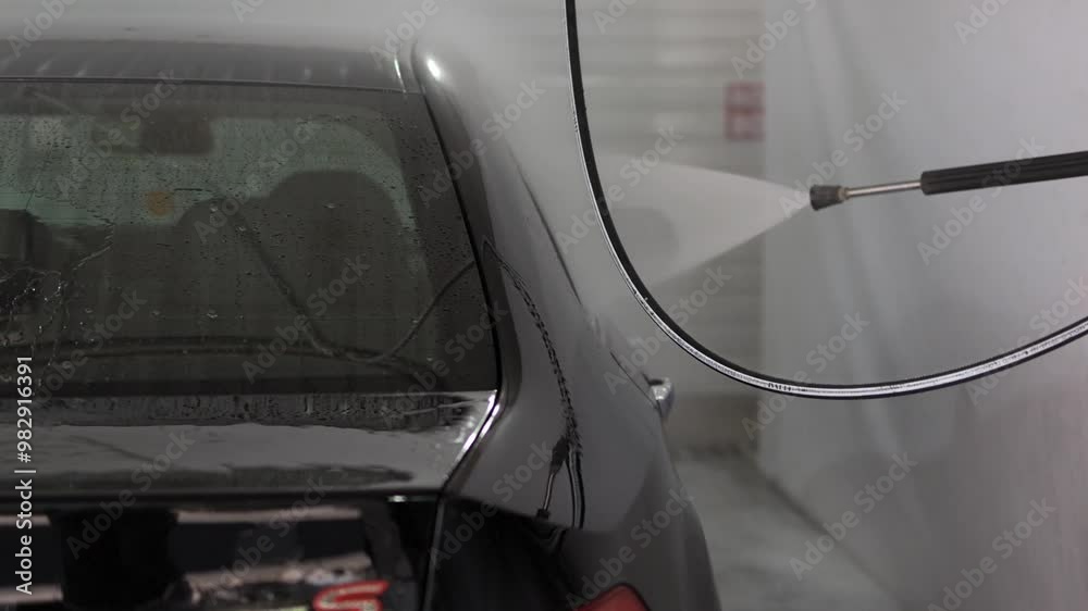 Black car at a self-service car wash. Black car at a self-service car wash.