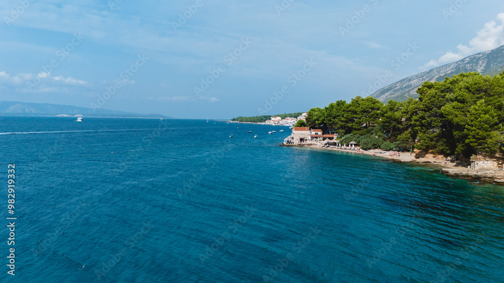 Obraz premium Along Croatia's coast, Brac Island invites visitors to explore its beautiful beaches, charming villages, and stunning natural wonders both above and below the vibrant blue waters.