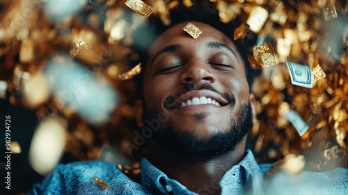 A man smiles blissfully while lying amid a shower of golden confetti and dollar bills, representing wealth, prosperity, and contentment in an opulent setting. photo