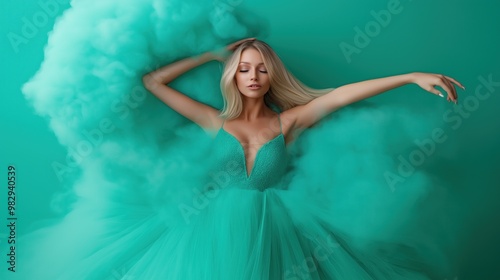 A graceful dancer showcases elegance in a striking turquoise gown surrounded by billowing turquoise smoke, enhancing the visual impact of the moment