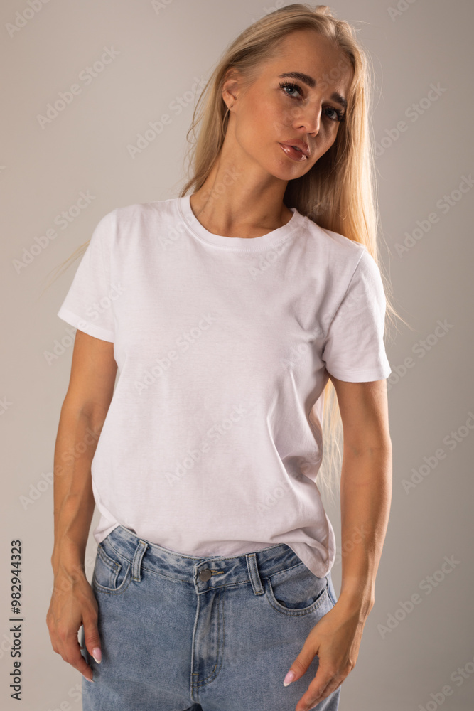 Blonde girl in white t-shirt and jeans posing on white background Blonde girl in white t-shirt and jeans posing on white background