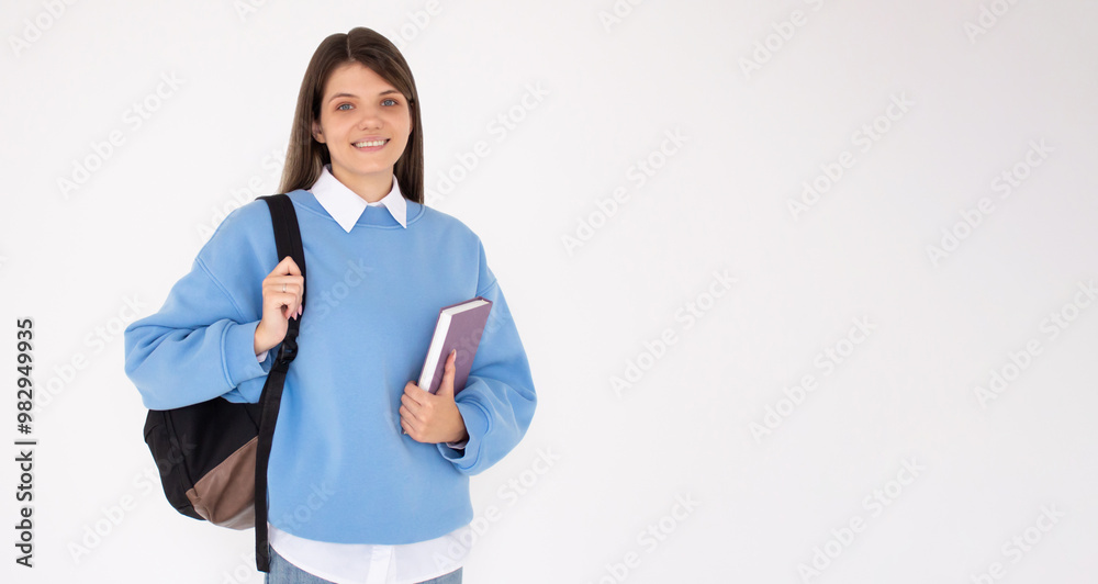 Caucasian girl student in blue sweatshirt with folder, books, notebook, notepad in hands smiling isolated on white studio background, copy space Caucasian girl student in blue sweatshirt with folder, books, notebook, notepad in hands smiling isolated on white studio background, copy space