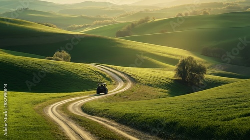 Winding country road through rolling green hills at sunset