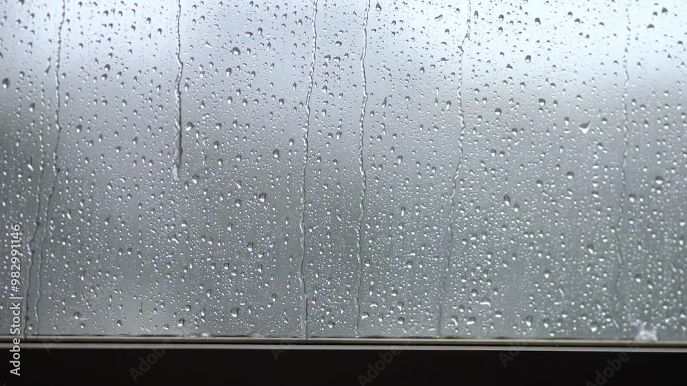 Rainy autumn weather, shower in fall, September, October, November. Inside view of window with dripping water, droplets falling outside. Dreary melancholic mood, sad upset emotions feelings concept.