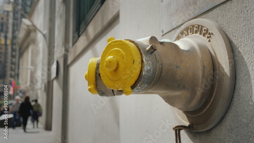 Yellow Fire hydrant in the wall of a building on Wall Street in New York photo