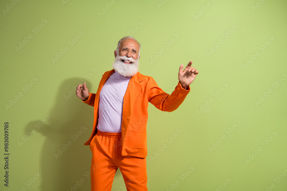 Fototapeta premium Portrait of funky eccentric grandfather dancing wear orange suit isolated on green color background