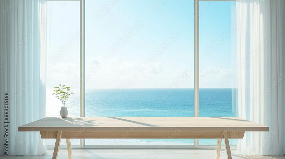 A light wooden work table in front of a bright window with a light blue ocean view A light wooden work table in front of a bright window with a light blue ocean view