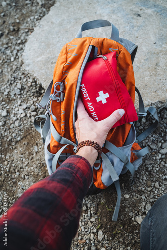 Preparing for an Exciting Adventure Carefully Packing a Comprehensive First Aid Kit into Your Backpack for Safety and Preparedness in the Wild photo