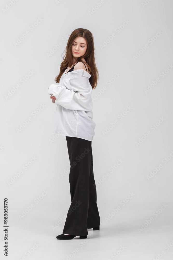girl model in black tight-fitting dress poses in studio on white background girl model in black tight-fitting dress poses in studio on white background