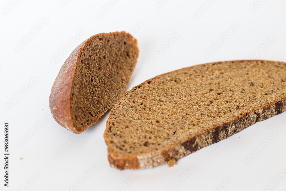 Close up shot of pieces of brown bread on white background. Food