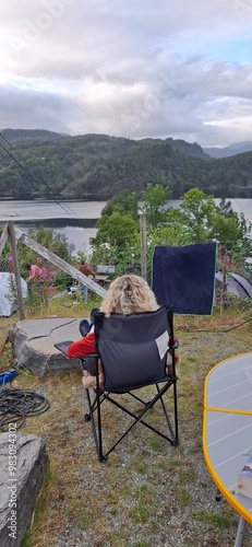 person sitting on a chair and looking at sea