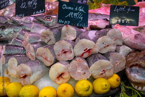 Assortment of fresh daily catch of prawns, seashells, molluscs on ice on fish market in Brittany, France, English translation: differens French names of seafood photo