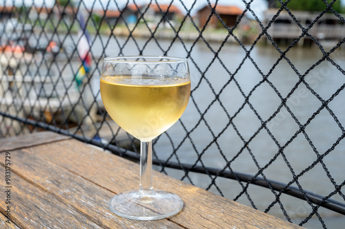 Tasting of Bordeaux white wine, right bank of Gironde Estuary, France. Glasses of white sweet French wine served in outdoor restaurant on oysters farm in Gujan-Mestras, Arcachon bay photo