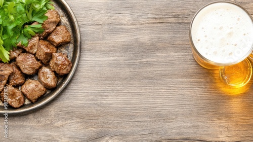 A delicious plate features grilled sliced beef steak accompanied by fresh rolls and a glass of beer, all beautifully arranged on a rustic wooden table