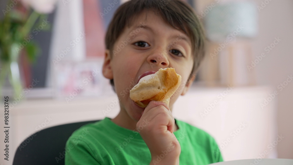 Young boy savoring a snack, with a playful expression on his face. the joy and innocence of childhood during a relaxed and carefree time at home Young boy savoring a snack, with a playful expression on his face. the joy and innocence of childhood during a relaxed and carefree time at home