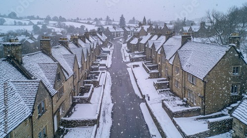Fototapeta Naklejka Na Ścianę i Meble -  A panoramic winter view of a small town with uniform stone houses, their thick walls holding back the cold, as a gentle snow falls over the quiet streets