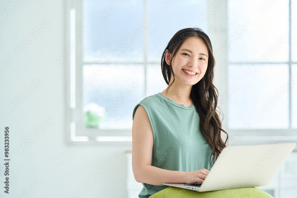 ノートパソコンで調べ物をする若い女性