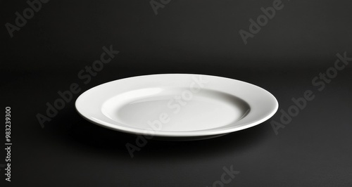 Simple white ceramic plate on a dark background showcasing elegant design and...