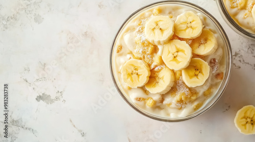 creamy banana pudding topped with fresh slices and sugar in glass bowl